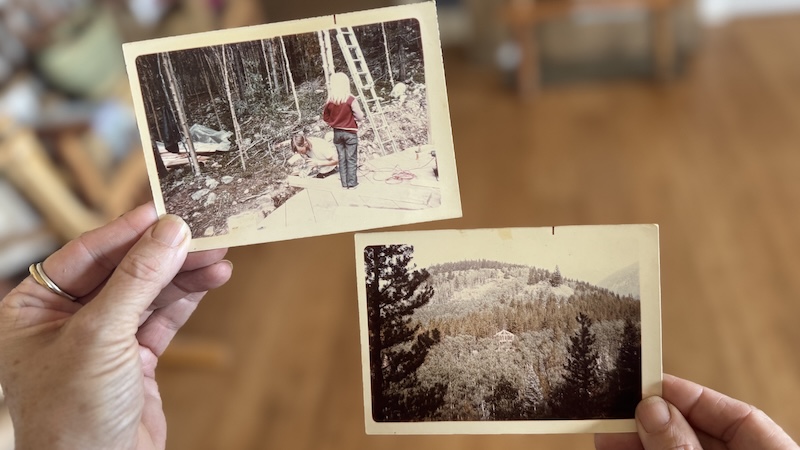 holding two old photographs: one of me as a young towheaded child standing on a board while it is being cut, the second is of the water tower at a far distance.
